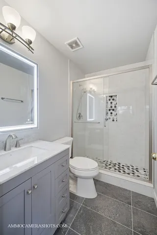 a spacious bathroom with a granite countertop sink a mirror and a shower
