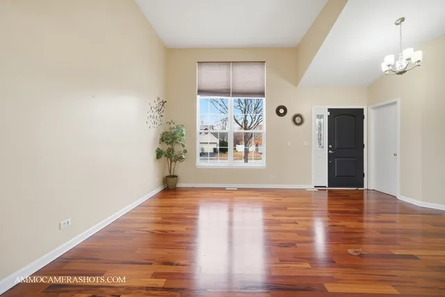 a view of a big room with wooden floor and windows
