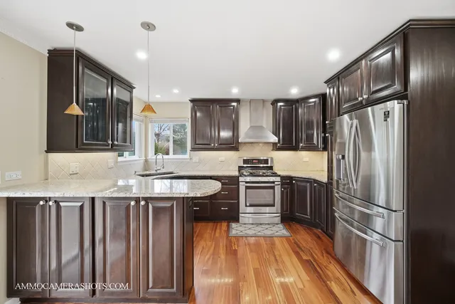 a kitchen with granite countertop a refrigerator and a sink