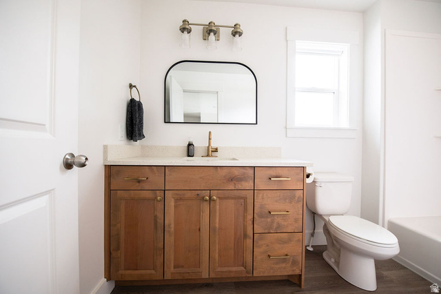 384 Ropelato Drive Nibley, UT 84321 - Photo 15 of 25 Wood-finish flooring with a white bathtub and toilet
