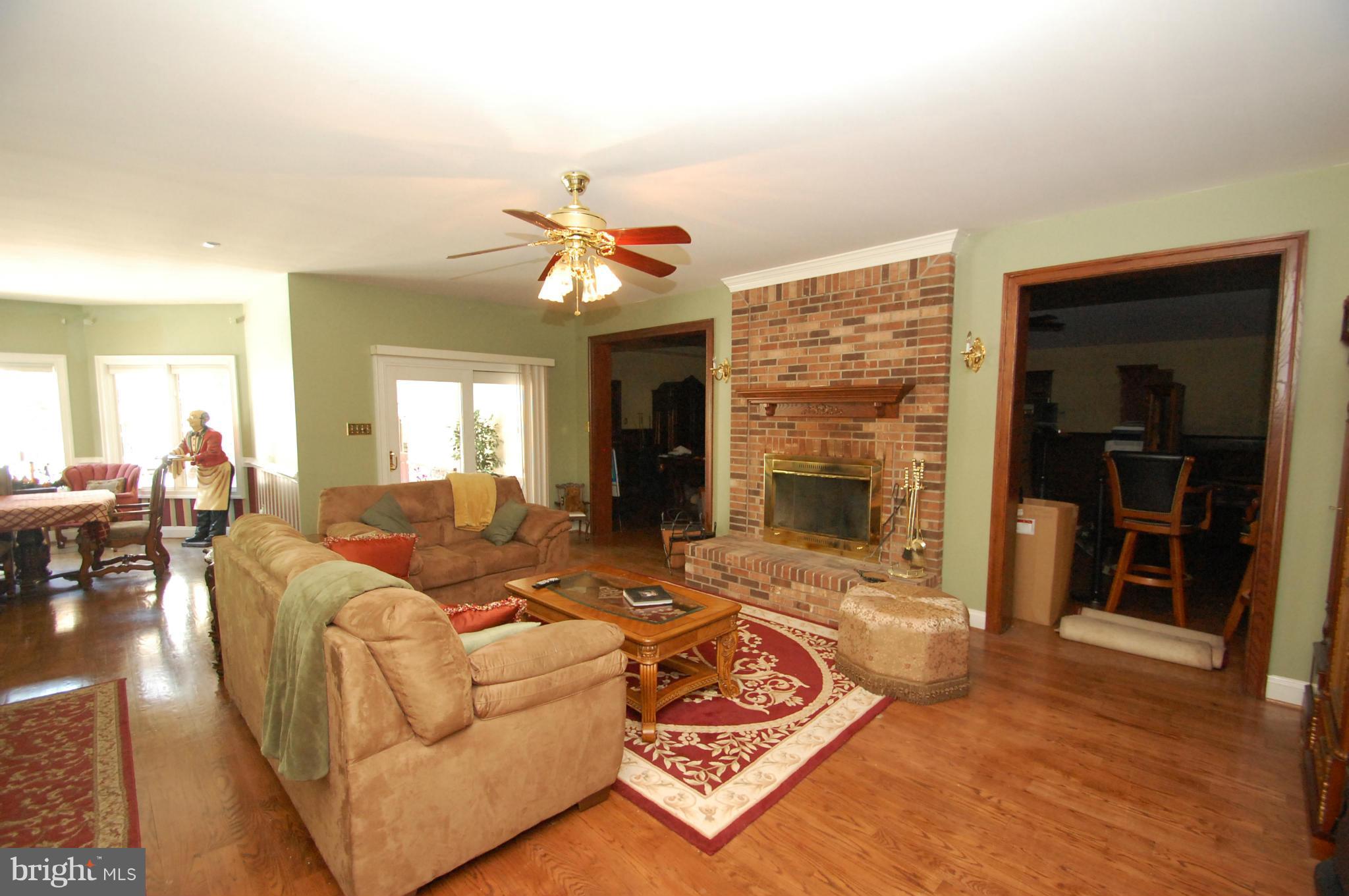 3840 Hooper Road New Windsor, MD 21776 - Photo 13 of 30 a living room with furniture a fireplace and a flat screen tv