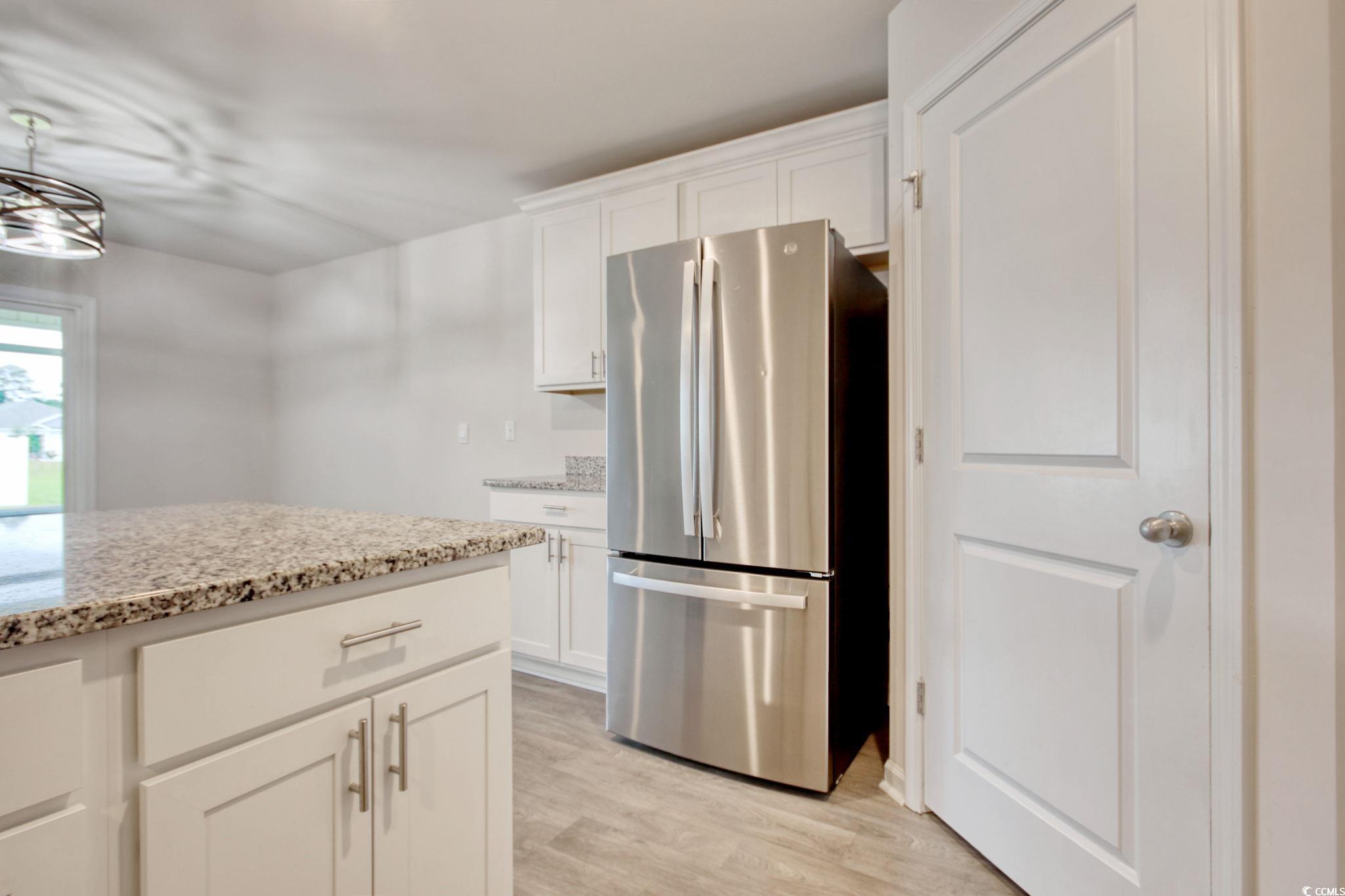 211 Seasons Trace Loop Longs, SC 29568 - Photo 15 of 37 Kitchen with freestanding refrigerator, light wood-type flooring, light stone counters, and white cabinets