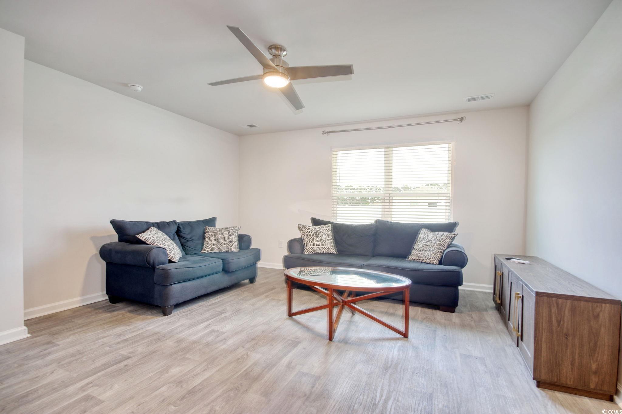 211 Seasons Trace Loop Longs, SC 29568 - Photo 16 of 37 Living area featuring light wood finished floors and ceiling fan
