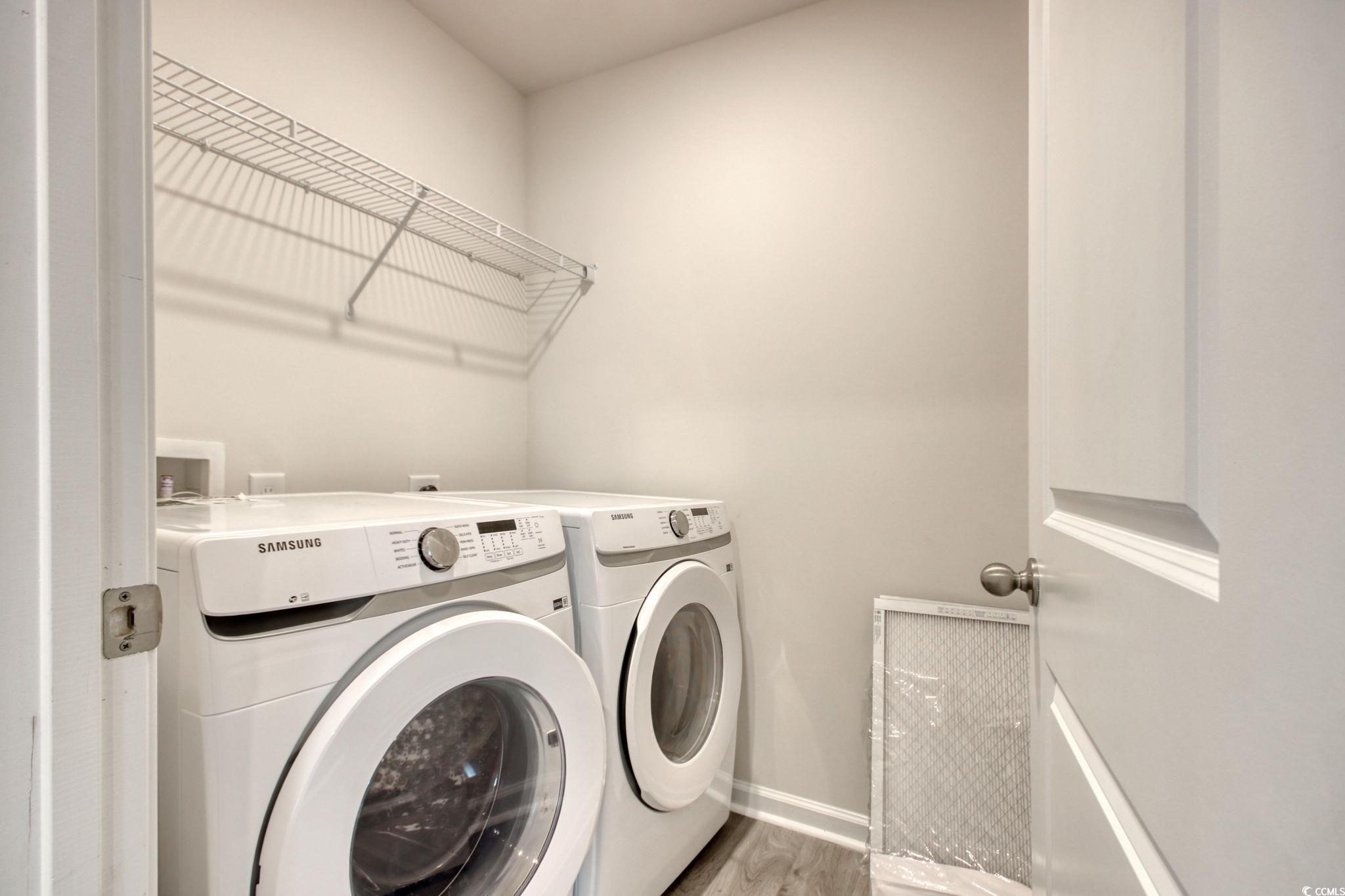 211 Seasons Trace Loop Longs, SC 29568 - Photo 32 of 37 Laundry area with washer and clothes dryer and wood finished floors