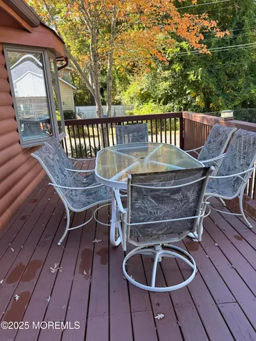 a balcony with wooden floor table and chairs