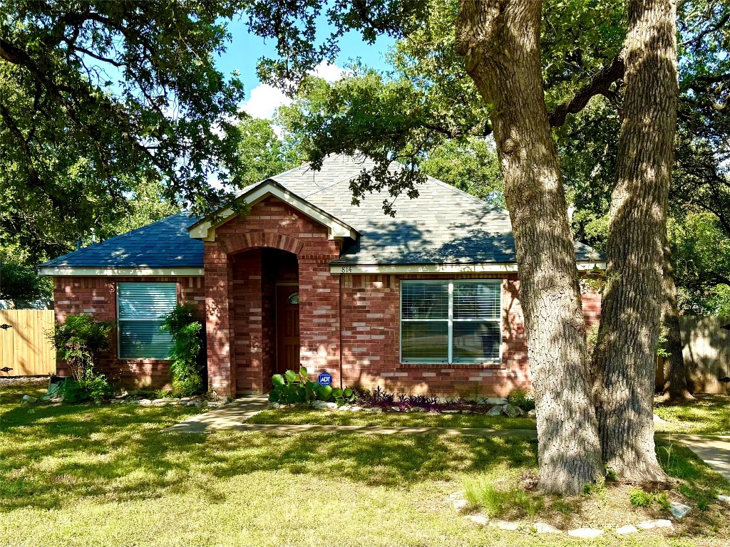 View of front of house with brick siding and a shingled roof