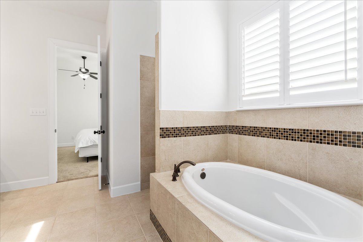 600 Garner Park Drive Georgetown, TX 78628 - Photo 13 of 39 Ensuite bathroom featuring a garden tub, light tile patterned floors, and ceiling fan
