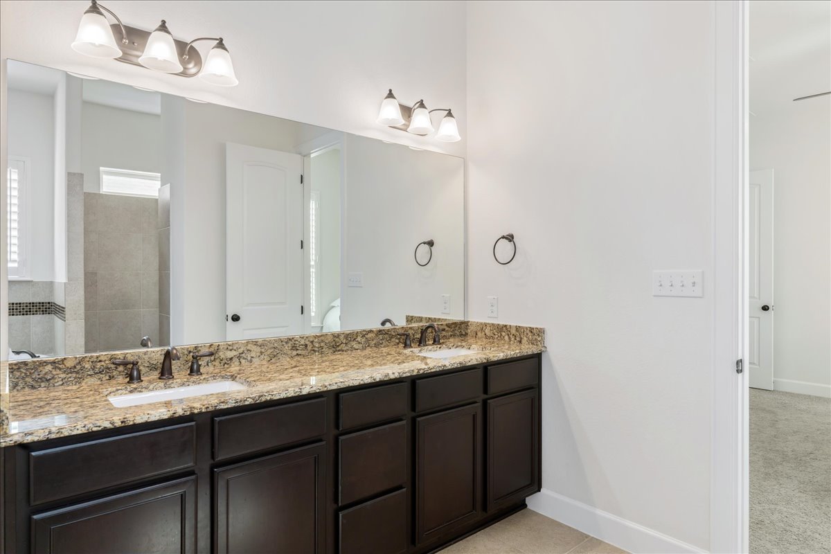 600 Garner Park Drive Georgetown, TX 78628 - Photo 14 of 39 Bathroom with double vanity, a tile shower, and light tile patterned flooring