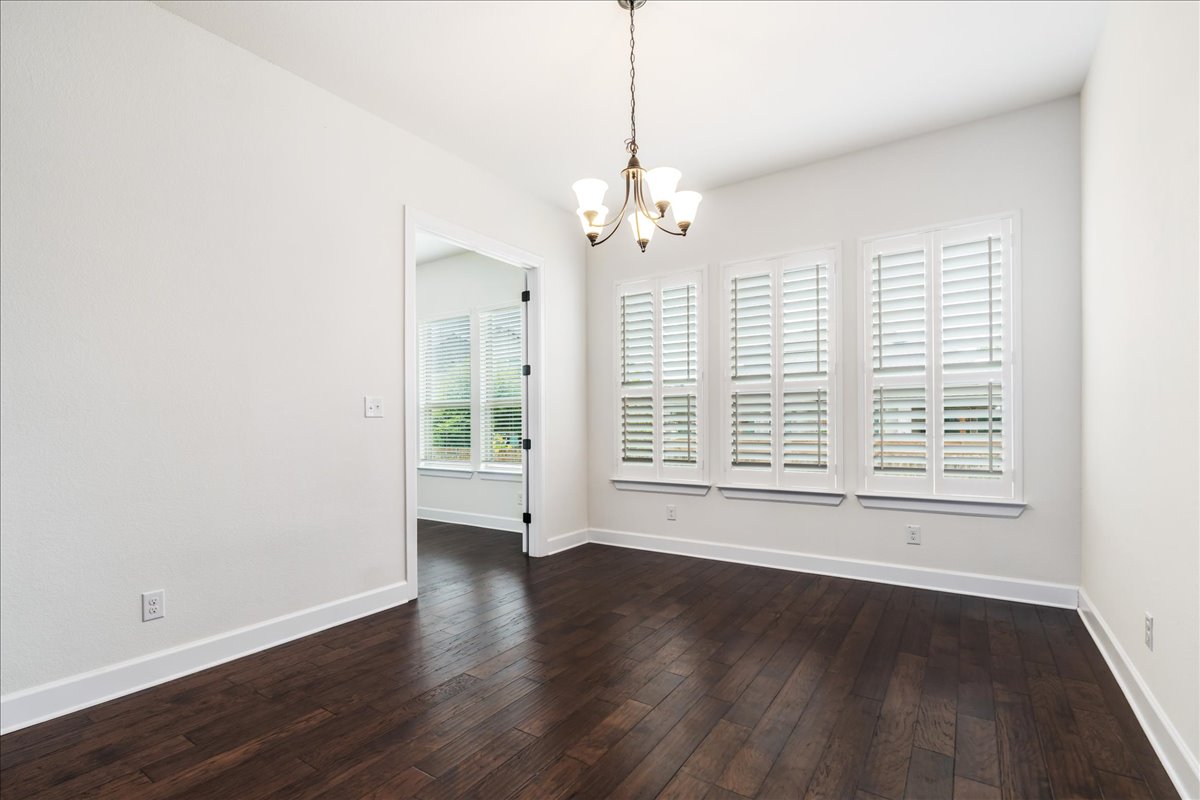 600 Garner Park Drive Georgetown, TX 78628 - Photo 22 of 39 Unfurnished dining area featuring dark wood finished floors and a chandelier