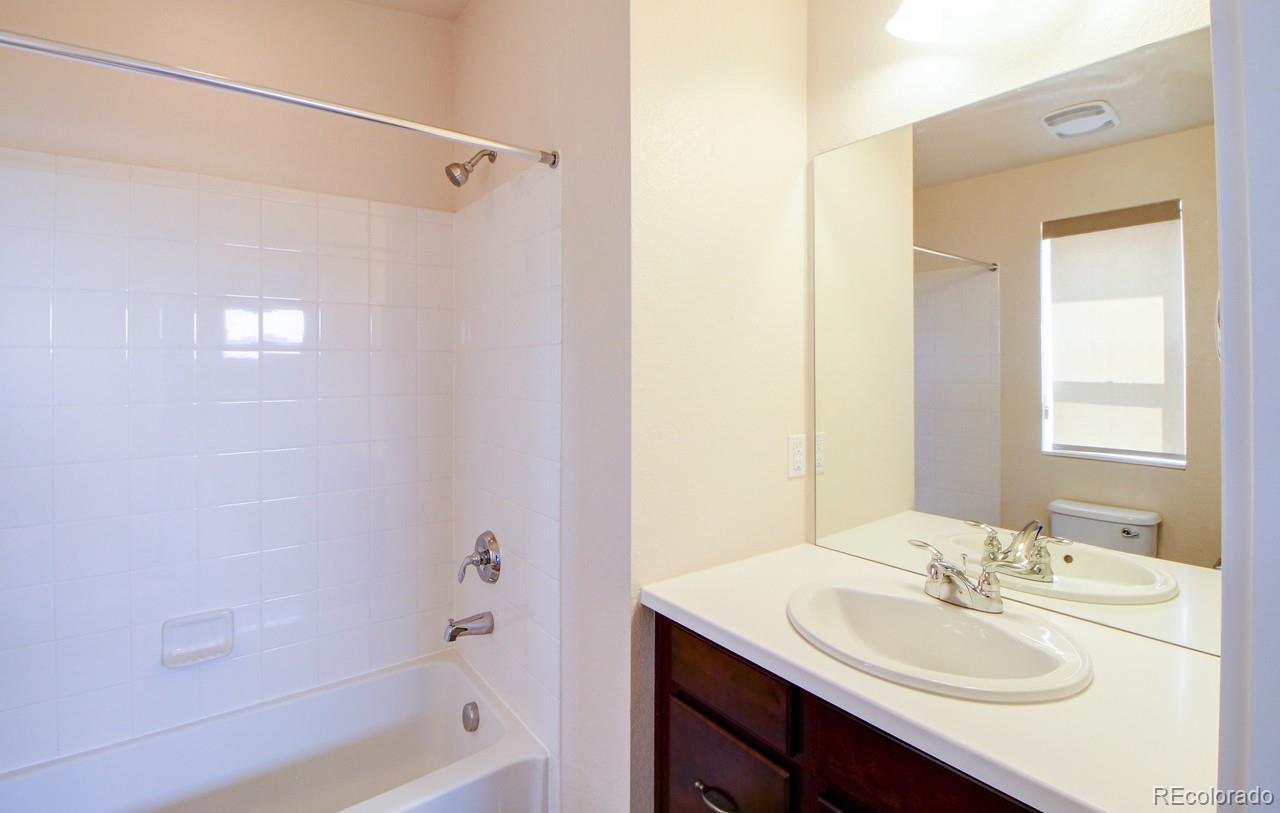 10122 Belvedere Loop Lone Tree, CO 80124 - Photo 14 of 17 a bathroom with a sink a mirror and a bathtub