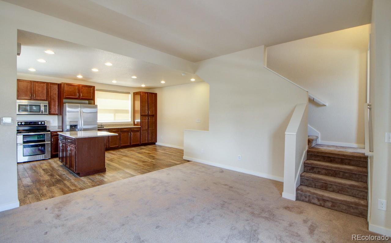 10122 Belvedere Loop Lone Tree, CO 80124 - Photo 8 of 17 a view of kitchen with stainless steel appliances kitchen island granite countertop a refrigerator and a sink