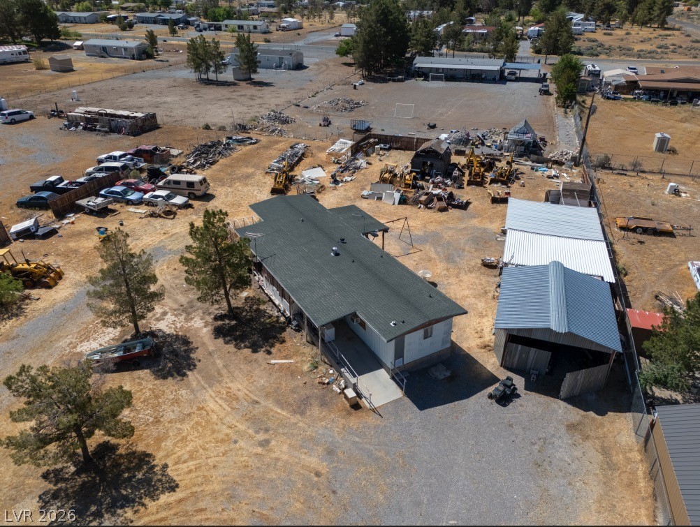 1301 East Manse Road Pahrump, NV 89048 - Photo 3 of 14 An aerial perspective reveals a single-story residence amidst a sprawling rural landscape with adjacent structures.