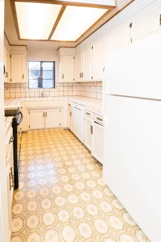 a spacious bathroom with a granite countertop toilet a sink and a mirror