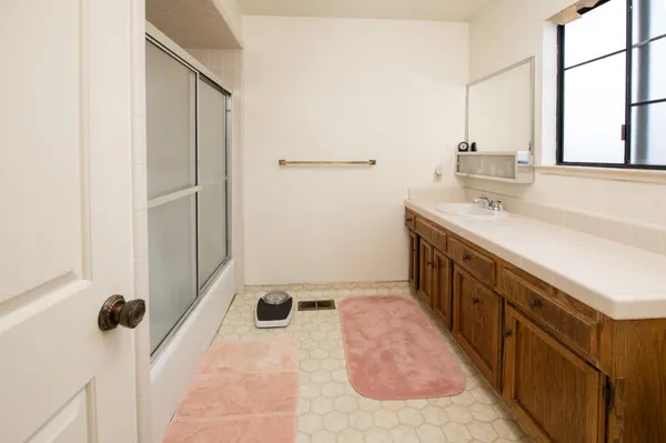 a spacious bathroom with a tub sink and mirror