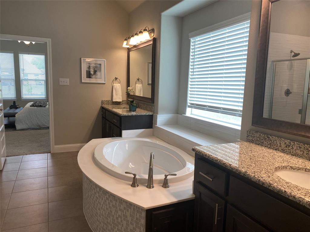 209 Johnson Street Granbury, TX 76048 - Photo 27 of 40 Bathroom featuring a healthy amount of sunlight, tile flooring, vanity, and separate shower and tub