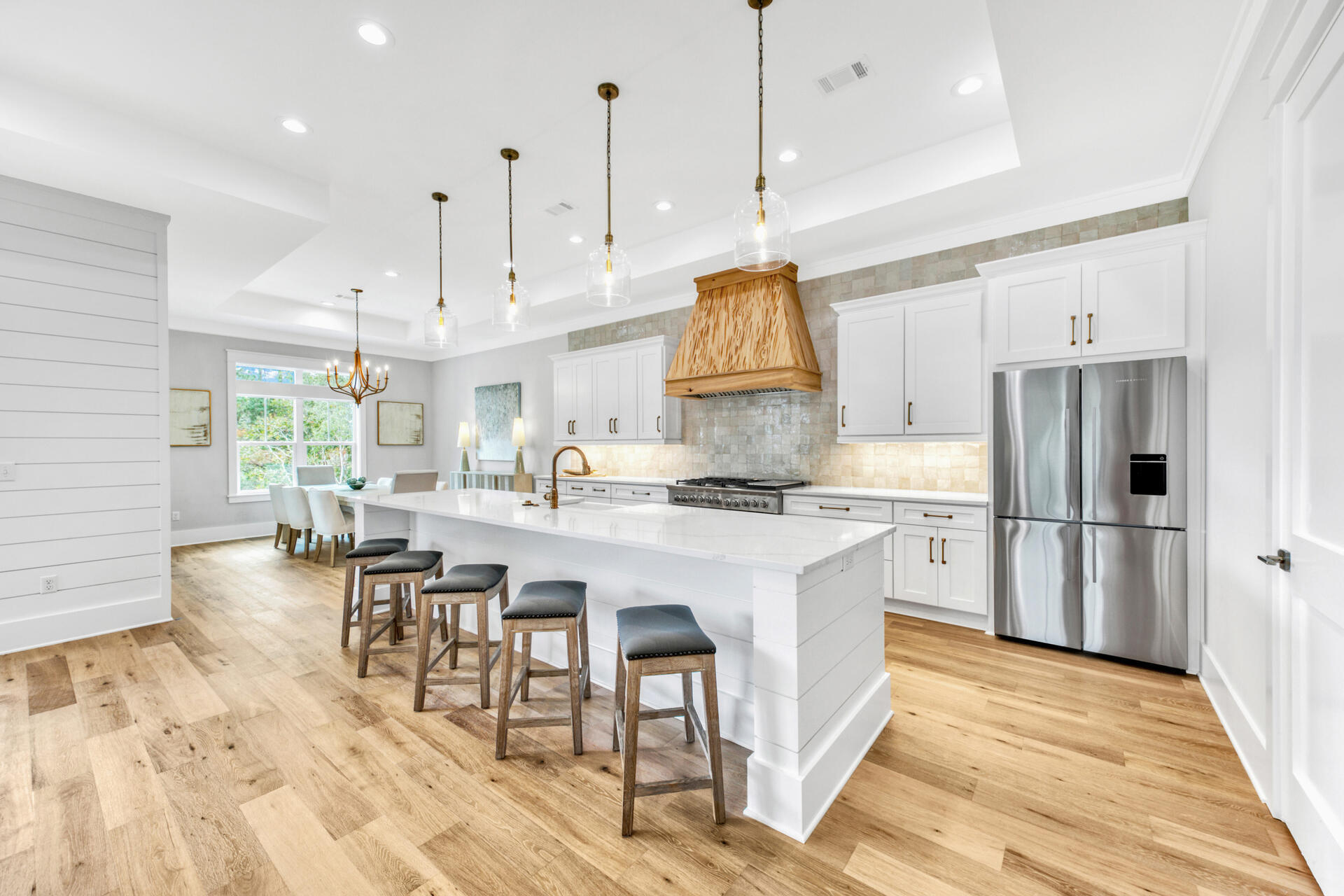 133 Dune Drive Santa Rosa Beach, FL 32459 - Photo 10 of 64 a kitchen with stainless steel appliances granite countertop a stove a refrigerator a oven a sink a island and chairs with wooden floor
