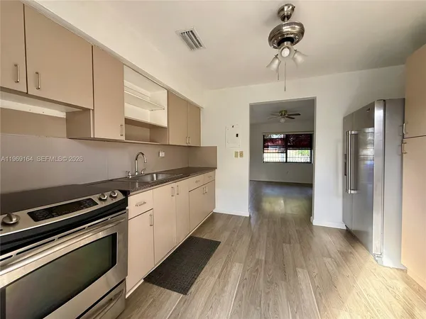a kitchen with granite countertop a stove cabinets and wooden floor