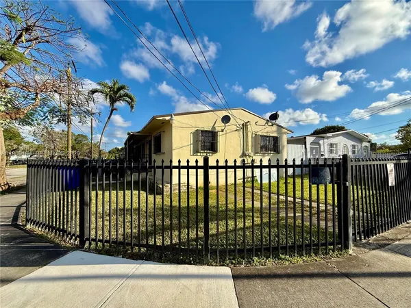 a view of a brick house with a small yard and plants