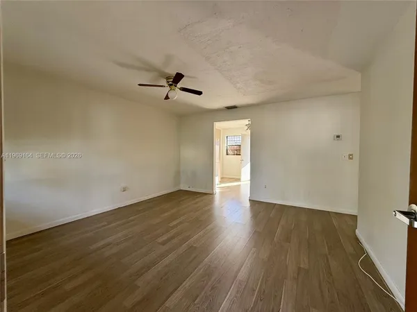 a view of a livingroom with wooden floor and a ceiling fan