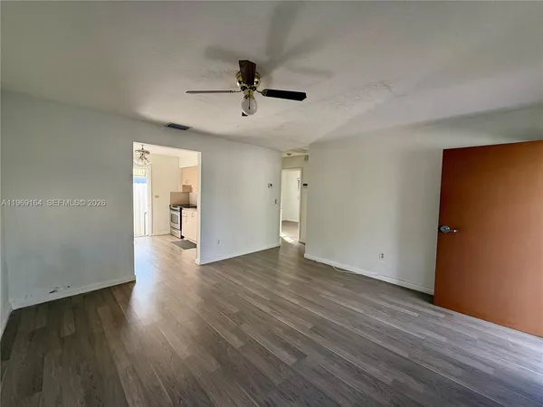 a view of empty room with wooden floor