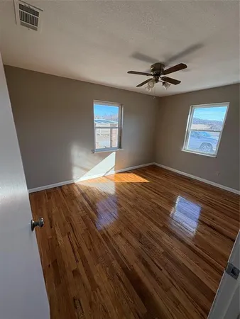 a view of empty room with wooden floor