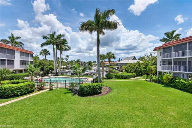 a view of a backyard with a garden and palm trees