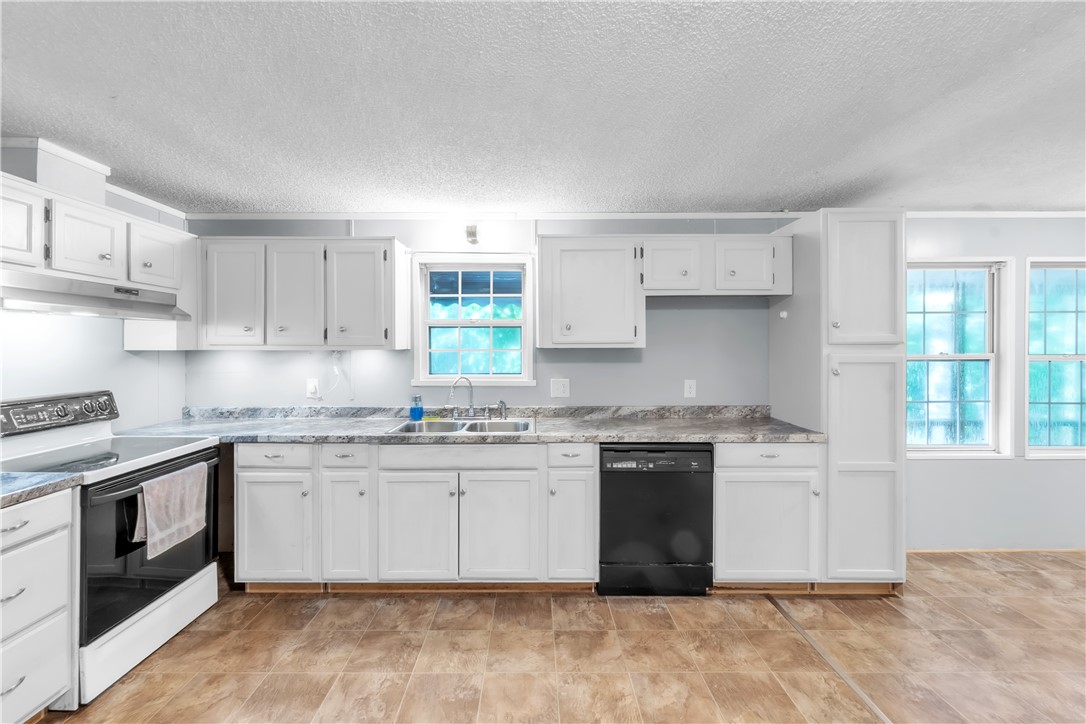178 Childress Road Pickens, SC 29671 - Photo 7 of 32 A well-appointed kitchen features ample white cabinetry, sleek countertops, and modern appliances, creating a highly functional culinary space.