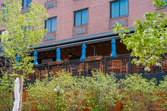 front view of a brick building with potted plants