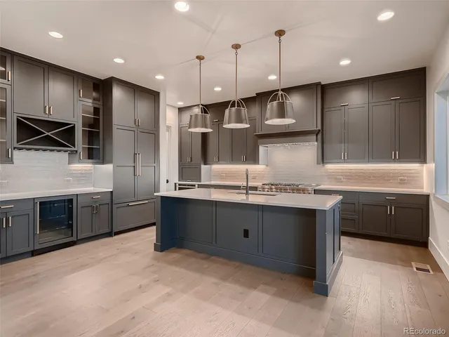 a kitchen with stainless steel appliances granite countertop a sink a stove and a refrigerator