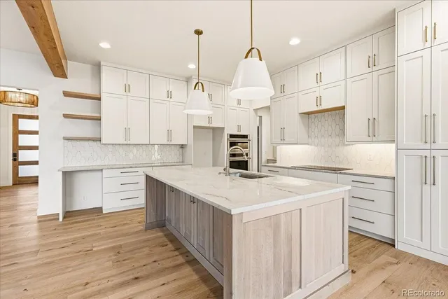 a kitchen with kitchen island a stove a sink a center island and a window