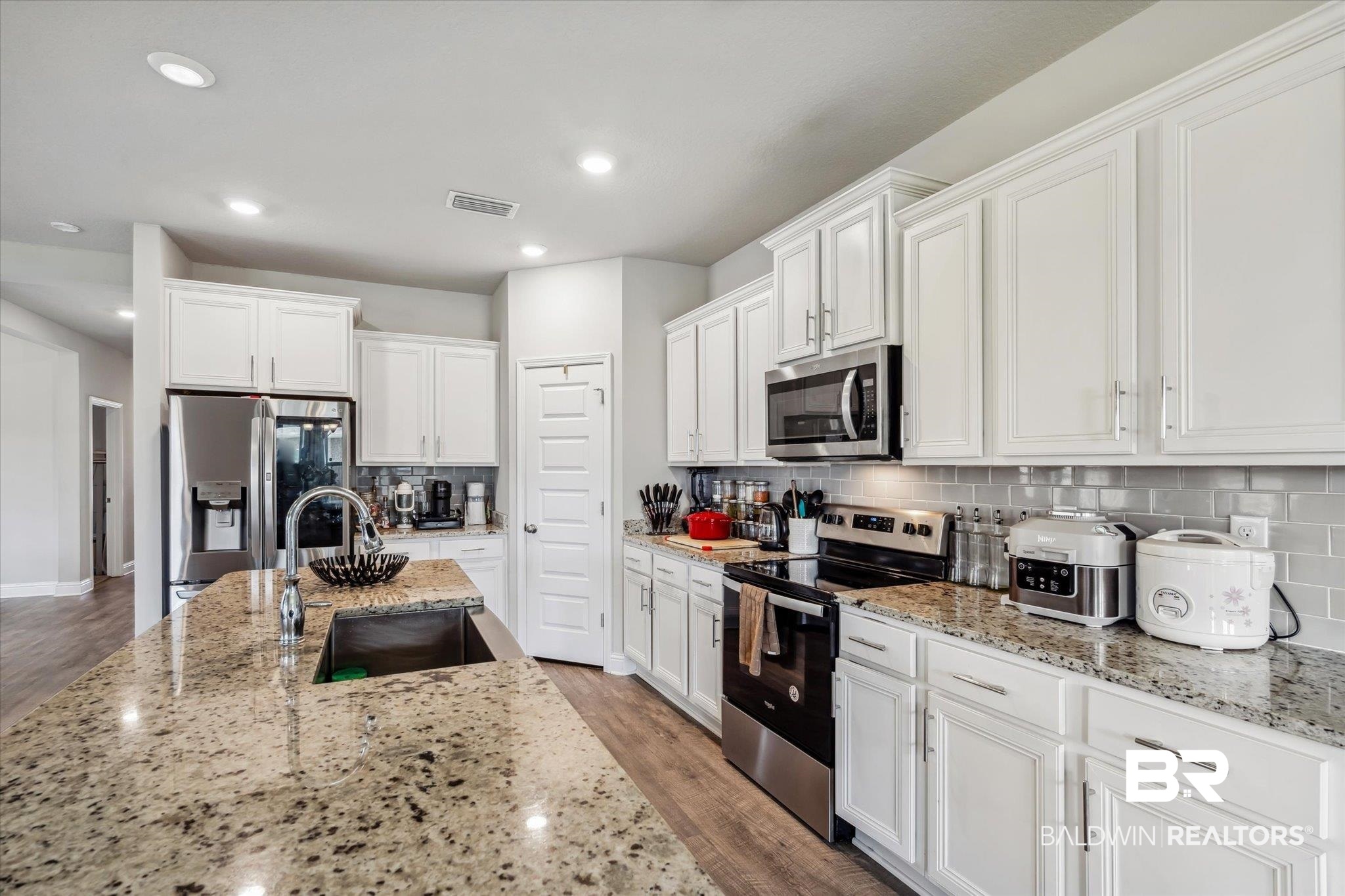 10501 Loamy Avenue Mobile, AL 36695 - Photo 7 of 30 Kitchen featuring sink, wood-type flooring, decorative backsplash, and stainless steel appliances