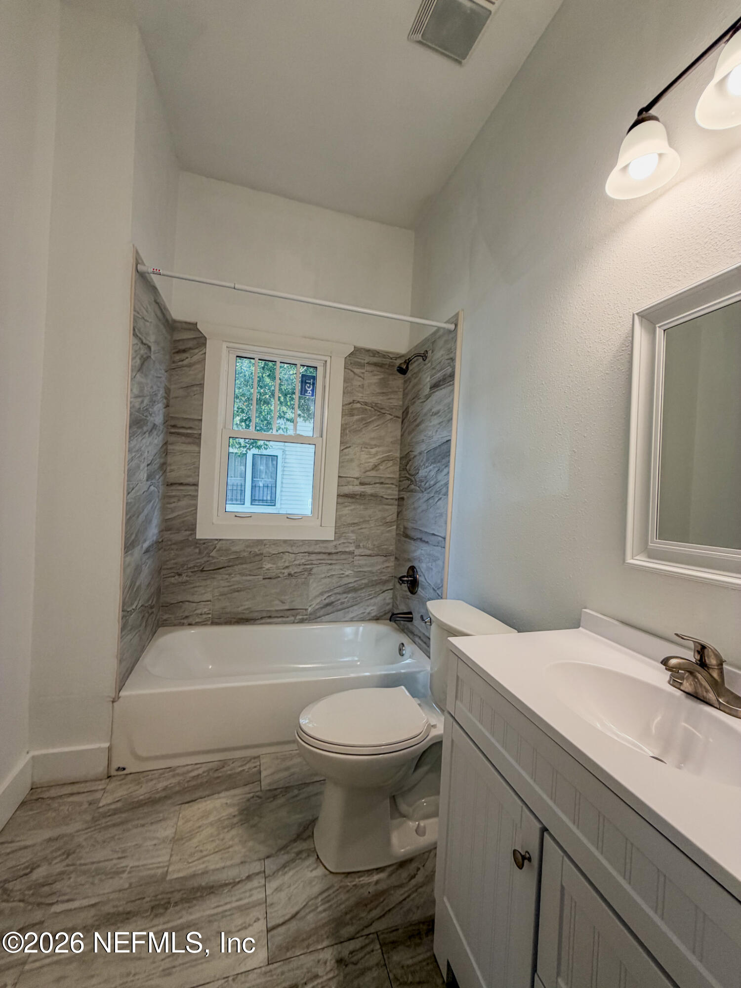 2589 Post Street Jacksonville, FL 32204 - Photo 16 of 19 a bathroom with a granite countertop toilet a sink and a bathtub