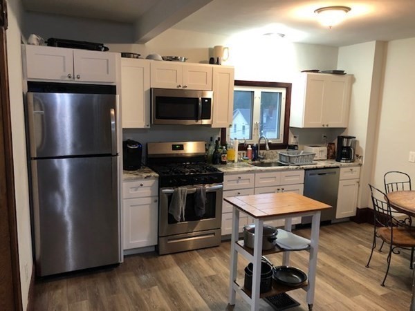 a kitchen with stainless steel appliances a refrigerator stove microwave and sink