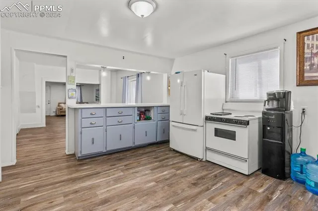 a kitchen with white cabinets and white appliances
