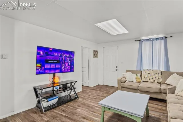 a living room with furniture and a wooden floor