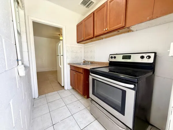 a kitchen with a stove top oven and cabinets