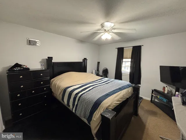 a bedroom with a bed and a flat tv screen on a dresser