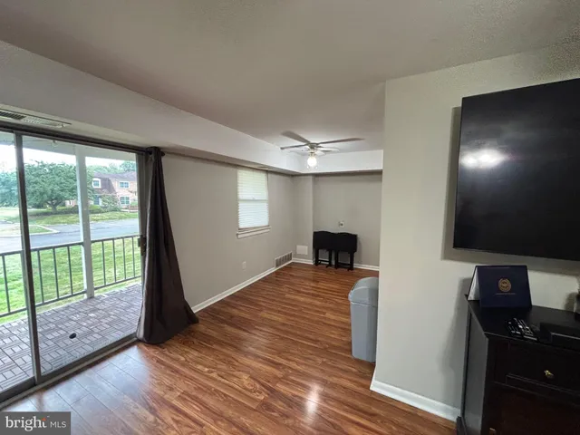a view of a livingroom with wooden floor and a flat screen tv