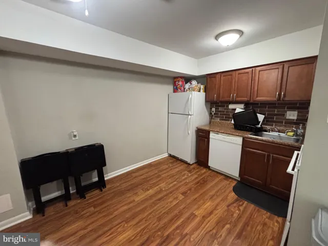 a kitchen with a sink a refrigerator and wooden cabinets