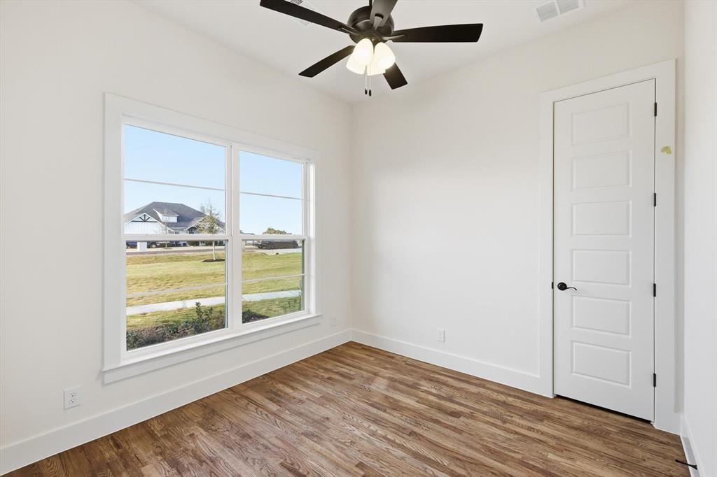 6412 Rigel Road Godley, TX 76044 - Photo 8 of 38 a view of an empty room with a window and wooden floor