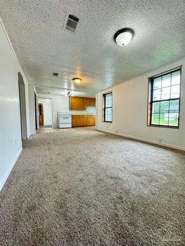 an empty room with fan and windows