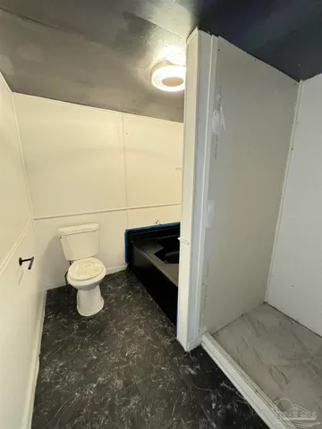 a bathroom with a toilet and a shower