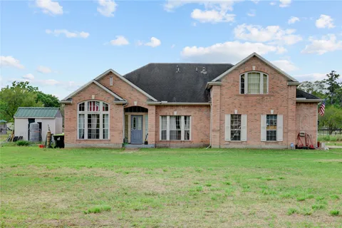 a front view of a house with a yard and trees