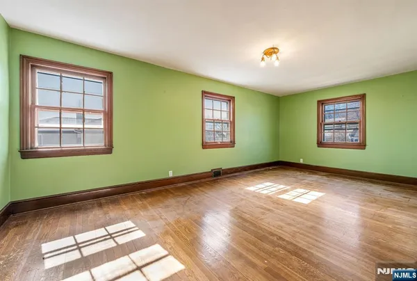 a view of empty room with window and wooden floor