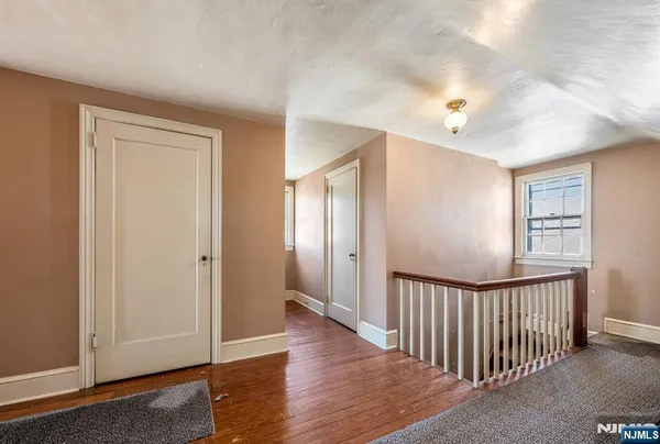 a view of a hallway with wooden floor and windows
