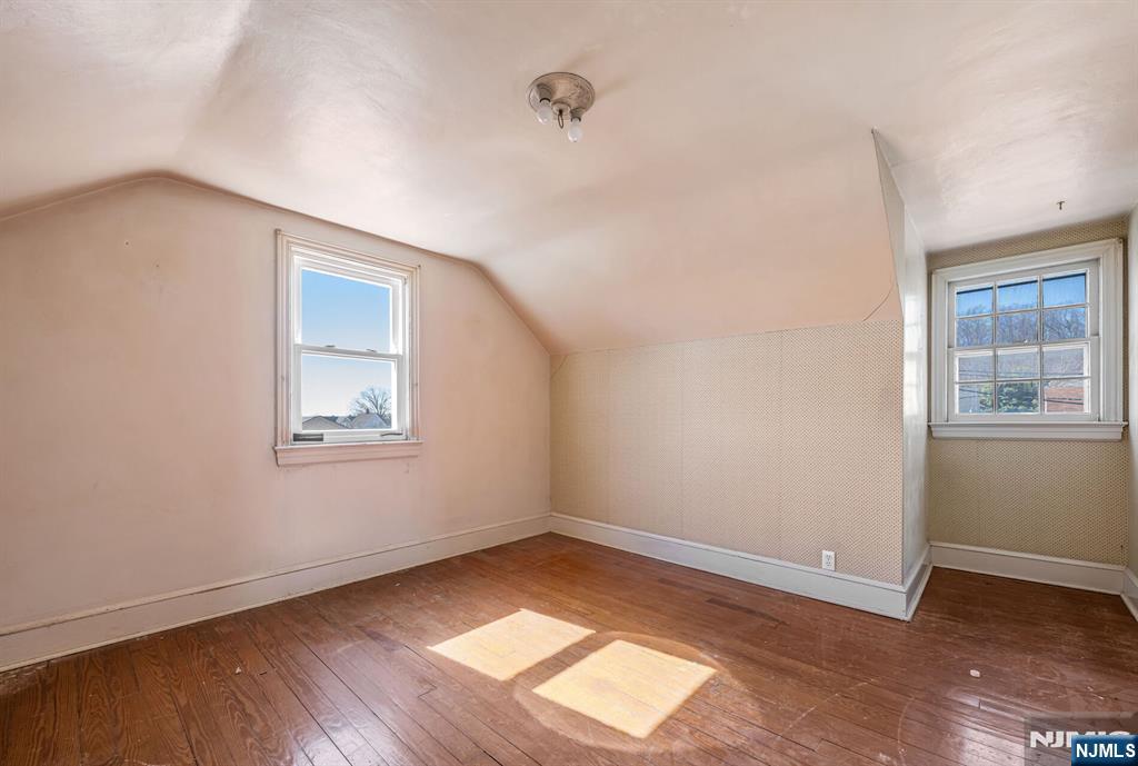 164 Chestnut Street Garfield, NJ 07026 - Photo 17 of 20 a view of an empty room with wooden floor and a window