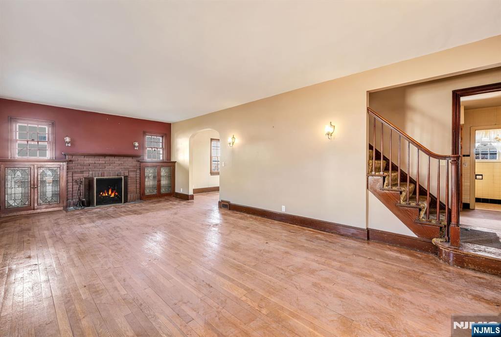 164 Chestnut Street Garfield, NJ 07026 - Photo 3 of 20 a view of an empty room with wooden floor fireplace and a window