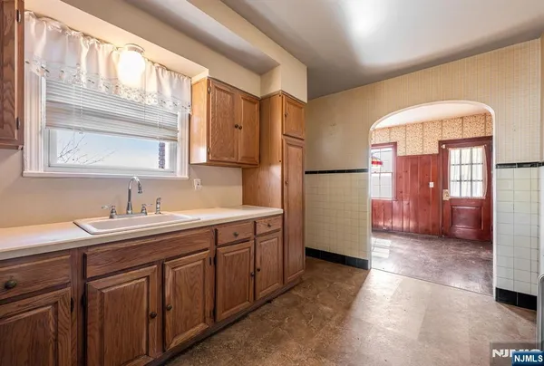 a kitchen with a sink a refrigerator and cabinets