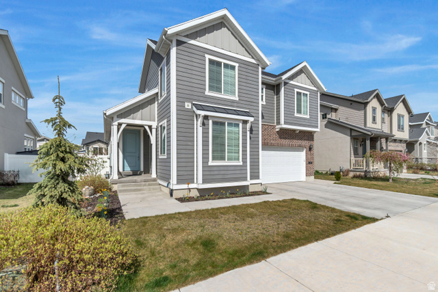 3232 West 1670th Street North Provo, UT 84601 - Photo 2 of 33 View of front facade with board and batten siding, driveway, brick siding, an attached garage, and a residential view