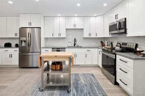 a kitchen with a stove a sink and a refrigerator